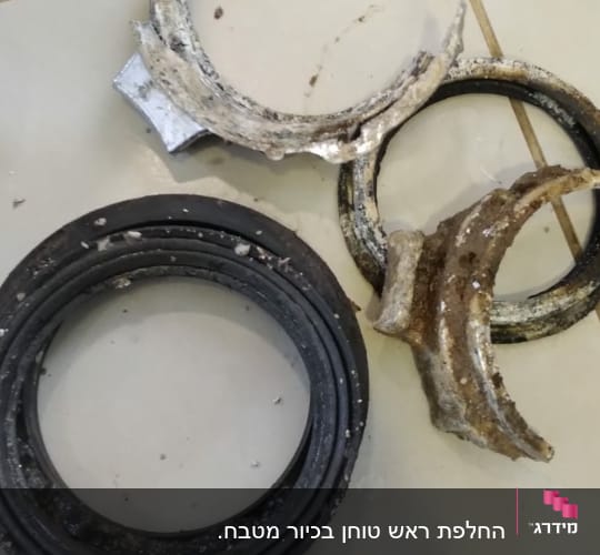 חלקי צינור שבורים ואטם גומי על רצפה